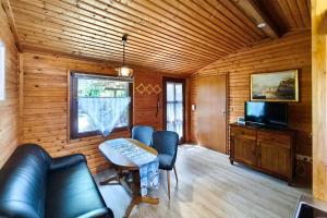 a living room with a couch and a table and a television at Ferienbungalow Seeluft in Loddin
