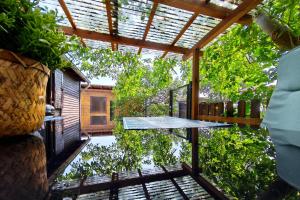 a glass table on a patio with a pergola at Ferienbungalow Seeluft in Loddin