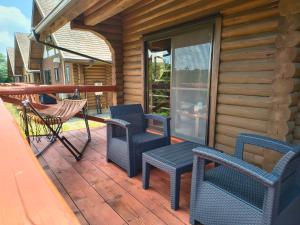 a wooden deck with chairs and a table and a swing at Maruta ひたち大宮 in Takabu
