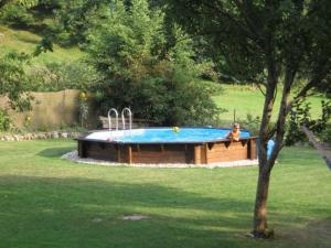a woman sitting in front of a swimming pool at Papilio in Montauban-de-Luchon