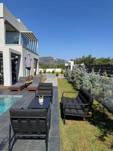 a villa with a swimming pool and black furniture at Mamica Luxury Villa in Laganas