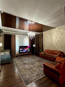 a living room with a couch and a television at Дача в городе in Bishkek
