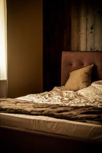 an unmade bed in a room with a window at Casa de Lângă Mesteceni in Dealu Negru +18 photos