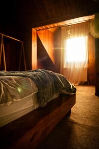 a bed in a room with a window with a curtain at Casa de Lângă Mesteceni in Dealu Negru