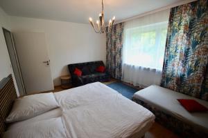 a bedroom with a bed and a chair and a window at Haus die Gerti - Ilz in Waldkirchen