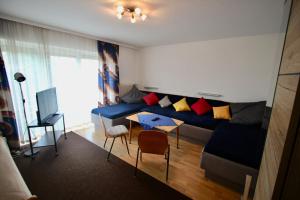 a living room with a blue couch and a table at Haus die Gerti - Ilz in Waldkirchen