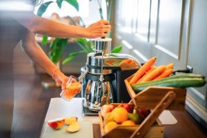 a person is making a drink in a blender at Tailormade Hotel METROPOL St Gallen in St. Gallen