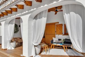 an archway in a living room with white curtains at Villa Enri | Oasis mediterráneo · Piscina in Parcent +31 photos