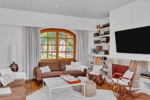 a living room with a couch and a flat screen tv at Villa Enri | Oasis mediterráneo · Piscina in Parcent