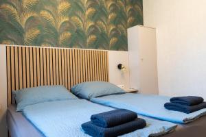 two beds in a room with blue towels on them at Luca Villa in Balatonlelle +8 photos