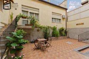 a patio with a table and chairs in front of a building at Etna in Belpasso