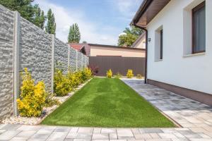 a garden with a retaining wall and green lawn at Luca Villa in Balatonlelle