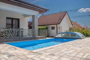 a swimming pool in front of a house at Luca Villa in Balatonlelle