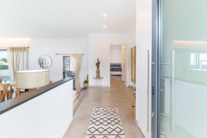 a living room with white walls and a dining room at Vila Adelino in Sines