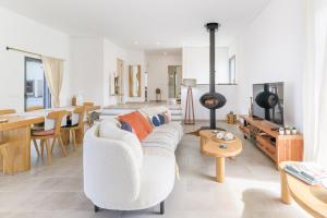 a living room with a white couch and a table at Vila Adelino in Sines
