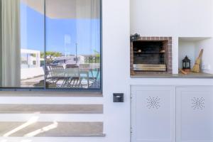 a living room with a fireplace and a window at Vila Adelino in Sines