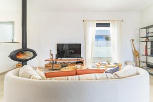 a living room with a white couch and a fireplace at Vila Adelino in Sines +29 photos