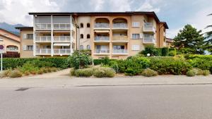 a large apartment building with bushes in front of it at Bright studio in Saillon, a few steps from Les Bains in Saillon
