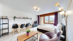 a living room with a bed and a table and chairs at Bright studio in Saillon, a few steps from Les Bains in Saillon