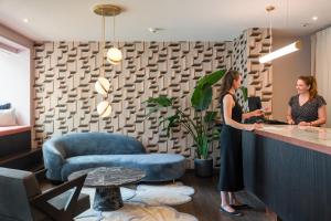 two women standing at a counter in a room at Tailormade Hotel METROPOL St Gallen in St. Gallen