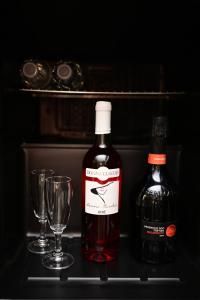 a bottle of wine and two glasses on a shelf at ASTRUM b&b in Cosenza