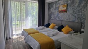 two beds in a hotel room with a window at Musa Hotel in Yeghegis