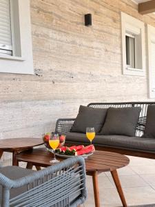 a patio with a couch and a table with two wine glasses at Apartmani Anđelo, Tommy, Leon in Bibinje