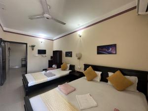 ein Hotelzimmer mit zwei Betten und einem Deckenventilator in der Unterkunft Muscat Holiday Resort in Cox's Bazar + 26 Fotos
