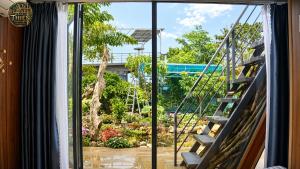a window with a view of a garden at Cổ Thiên Thạch Kiếm in Ðại Lào