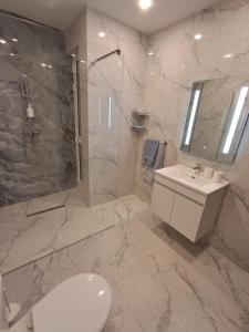 a bathroom with a toilet and a sink and a shower at Caterina Suites in Wied l-Arkata +11 photos