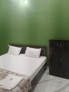 a bedroom with a large bed and a wooden cabinet at Ayodhya Stay in Ayodhya