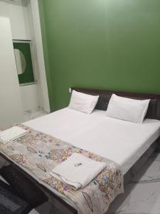 a bed with white pillows and towels on it at Ayodhya Stay in Ayodhya