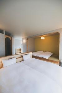 ein Schlafzimmer mit einem großen weißen Bett mit Kopfteil in der Unterkunft cuccou in Aira