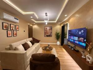 a living room with a couch and a flat screen tv at Pedro suite by iconic apartment in Lagos