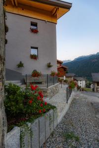 a house with red flowers on the side of it at Adamello skyline in Temù