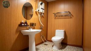 a bathroom with a toilet and a sink and a mirror at Cổ Thiên Thạch Kiếm in Ðại Lào
