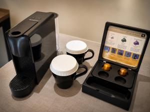 a small electronic device with three cups and a box at The Litton Hotel by Carterson in Naga