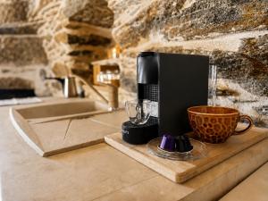 a coffee maker and a cup on a counter at Nostos Kea in Káto Meriá