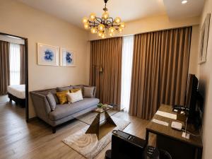 a living room with a couch and a chandelier at The Litton Hotel by Carterson in Naga +16 photos
