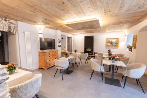 a living room with tables and chairs and a television at Adamello skyline in Temù