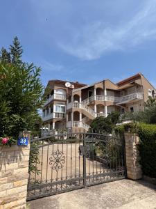 a large building with a gate in front of it at Apartmani Anđelo, Tommy, Leon in Bibinje