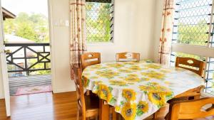 a dining room with a table and chairs and a window at Auki Ocean View in Auki