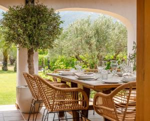 a wooden table with chairs and a table with glasses at Villa Enri | Oasis mediterráneo · Piscina in Parcent