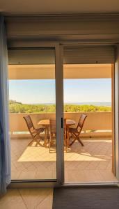 a sliding glass door of a patio with a table and chairs at Vista Mare a Isola Verde in Isola Bacucco