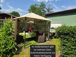 a gazebo with a table in a garden at Neu!!! Pension Scherz-ruhig am Standrand mit Wasserzugang & Paddelboot in Lübbenau +6 photos