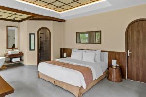a bedroom with a large bed and a bathroom at Cuc Phuong Tropical Villas in Thượng Sung +24 photos