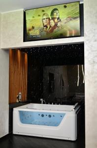 a tv hanging above a white tub in a bathroom at ASTRUM b&b in Cosenza