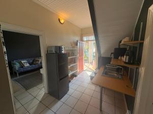 a small kitchen with a refrigerator and a table at The Sync Inn in Gqeberha