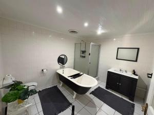 a bathroom with a tub and a sink and a shower at The Sync Inn in Gqeberha
