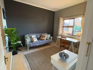 a living room with a couch and a table at The Sync Inn in Gqeberha